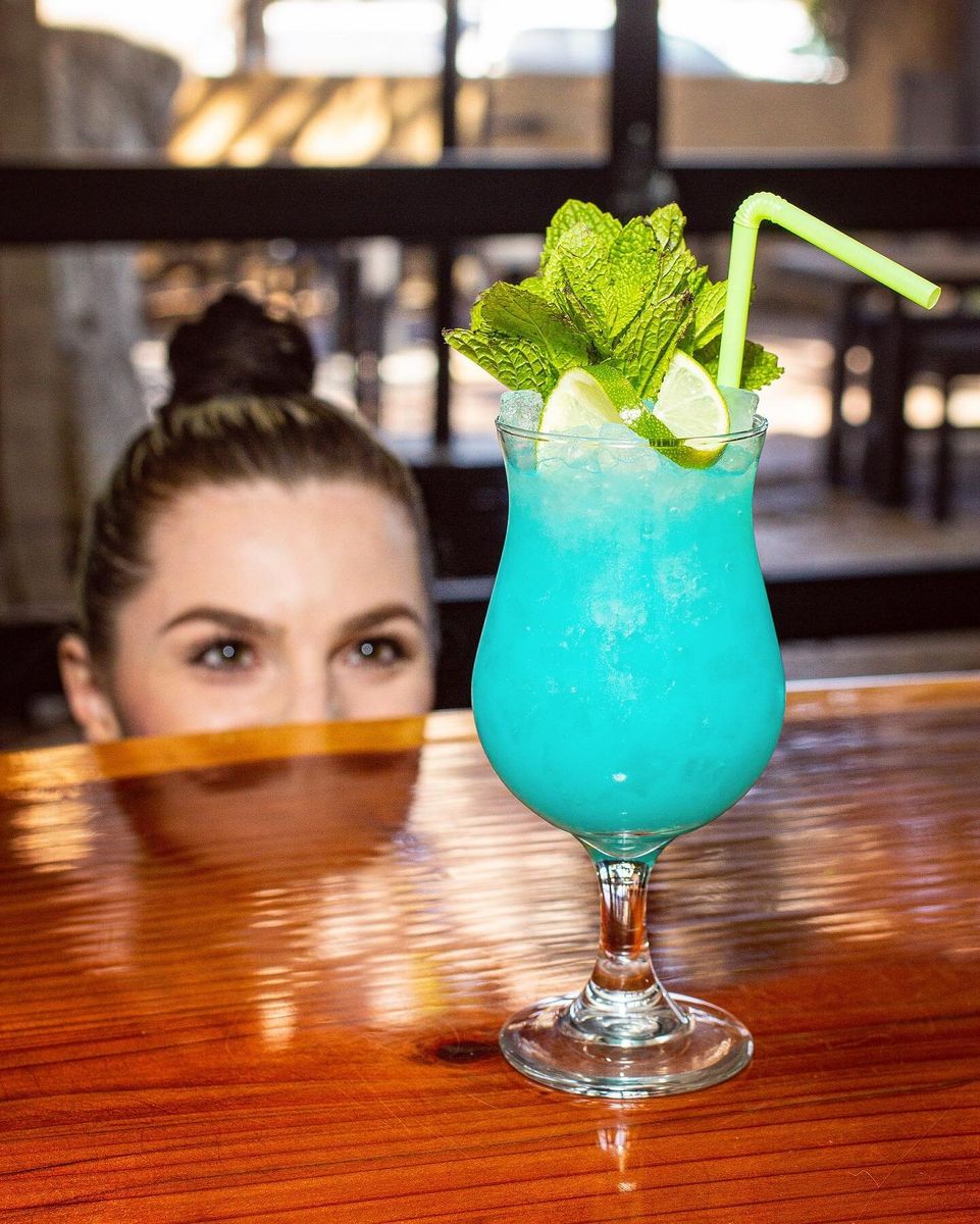 Bright blue tropical cocktail with mint served at The Golden Pineapple bar in Tempe