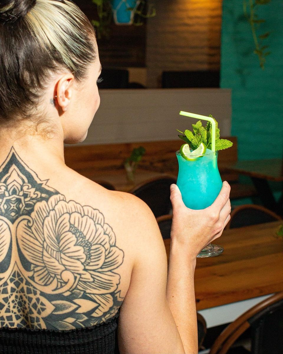 Guest enjoying a blue tropical cocktail inside the lounge